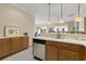 Kitchen area with stainless steel dishwasher and wooden cabinets at 98 Wallys Way # 1, Pawleys Island, SC 29585