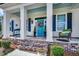 Inviting front porch showcasing classic columns, seating, decorative accents, and a vibrant blue door at 1006 James Island Ave., North Myrtle Beach, SC 29582
