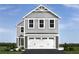 Charming two-story home with gray siding and a two-car garage beneath the main structure at 1174 Oak Meadow Dr., Conway, SC 29526
