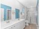 Bright bathroom features a double vanity, a glass-enclosed shower, and beach themed artwork at 1119 Maxwell Dr., Little River, SC 29566