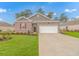 Charming single-story brick home with manicured lawn and two-car garage under a bright, sunny sky at 1119 Maxwell Dr., Little River, SC 29566