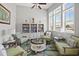 Bright living room featuring a full bookshelf and seating near large windows at 1186 Pyxie Moss Dr., Little River, SC 29566