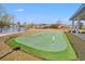 Community putting green with a lake in the background and well-manicured grass at 1186 Pyxie Moss Dr., Little River, SC 29566