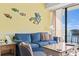 Cozy living room features a blue sofa and a sliding glass door with balcony overlooking the ocean at 1210 N Waccamaw Dr. # 1507, Murrells Inlet, SC 29576