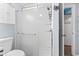 Bright bathroom with toilet and a glass-door shower featuring built-in shelves at 123 N Dogwood St. # 107, Garden City Beach, SC 29576