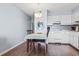 Dining area and kitchen featuring white cabinets and hardwood floors at 123 N Dogwood St. # 107, Garden City Beach, SC 29576