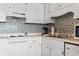 Bright kitchen featuring an oven, stainless steel sink, and mosaic backsplash at 123 N Dogwood St. # 107, Garden City Beach, SC 29576