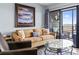 Cozy living room with plush sofa, beachy artwork, and a sliding glass door to the balcony at 123 N Dogwood St. # 107, Garden City Beach, SC 29576