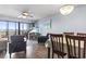 Living room featuring a dining table, flatscreen television, and access to balcony at 123 N Dogwood St. # 107, Garden City Beach, SC 29576