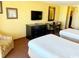 Cozy bedroom with two beds, a TV, a dining table, and a striped armchair at 1501 S Ocean Blvd. # 1203, Myrtle Beach, SC 29577