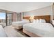 Bright bedroom featuring two queen beds, wood-look floors, and a balcony with ocean views at 1501 S Ocean Blvd. S # 1147, Myrtle Beach, SC 29577