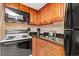 Efficient kitchen with wood cabinets, black appliances, and granite countertops at 1501 S Ocean Blvd. S # 1147, Myrtle Beach, SC 29577