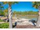 Waterfront view featuring a fire pit on a stone patio surrounded by palm trees at 204 Juniata Loop, Little River, SC 29566