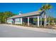 Community clubhouse exterior with covered seating area, black metal fence, and lush landscaping at 204 Juniata Loop, Little River, SC 29566