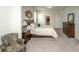 Relaxing main bedroom features a plush bed, wood dresser, and a comfortable chair, bathed in natural light at 204 Juniata Loop, Little River, SC 29566
