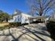 Exterior elevation of home showing covered driveway and lush landscaped lawn at 213 S Farr Ave., Andrews, SC 29510