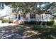 Inviting front porch with white columns and relaxing rocking chairs on landscaped lawn at 213 S Farr Ave., Andrews, SC 29510