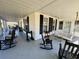 Expansive wraparound porch adorned with rocking chairs and a swing, perfect for enjoying the outdoors at 213 S Farr Ave., Andrews, SC 29510