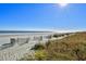A beautiful beach view with sand dunes and a fence stretching along the coastline and ocean in the distance at 217 N Myrtle St. # 1, Myrtle Beach, SC 29577