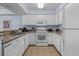 Bright kitchen featuring white appliances, cabinets, and granite countertops, offering a clean aesthetic at 2201 S Ocean Blvd. # 1707, Myrtle Beach, SC 29577