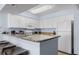 Well-lit kitchen boasts white cabinets, granite counters, and bar seating for a modern, inviting space at 2201 S Ocean Blvd. # 1707, Myrtle Beach, SC 29577