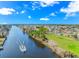 Stunning aerial perspective showcasing the waterway, residential homes, and golf course with a boat creating a wake at 2212 Via Palma Dr., North Myrtle Beach, SC 29582