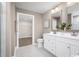 Bright bathroom featuring double vanity with white cabinetry and a walk-in closet entrance at 228 Bent Green Ct. # 48C, Murrells Inlet, SC 29576