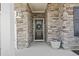 Charming front porch with stone details, hanging outdoor light and wreath on front door at 236 Craigflower Ct., Longs, SC 29568
