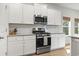 Stylish kitchen boasts stainless steel appliances, white cabinetry, and tiled backsplash at 236 Craigflower Ct., Longs, SC 29568