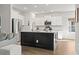 Open-concept kitchen with a large island, stainless steel refrigerator, and white cabinetry at 236 Craigflower Ct., Longs, SC 29568
