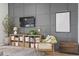 Stylish living room features a paneled wall, modern TV, and a curated display shelf with decor at 236 Craigflower Ct., Longs, SC 29568