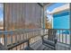 Relaxing balcony area with seating, privacy screen, and view of the charming blue house next door at 2406 Seabreeze Pl., Myrtle Beach, SC 29577