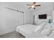 Cozy bedroom featuring a comfortable bed, wood floors, barn door, ceiling fan, and a mounted TV at 2406 Seabreeze Pl., Myrtle Beach, SC 29577