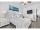 Comfortable bedroom featuring hardwood flooring, a mounted TV, a decorative painting, and white furniture at 2406 Seabreeze Pl., Myrtle Beach, SC 29577