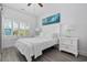 Serene bedroom with white decor, shuttered window, and a striking blue wave painting at 2406 Seabreeze Pl., Myrtle Beach, SC 29577