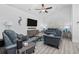 Cozy living room features blue leather seating, ceiling fan and large tv, perfect for relaxing and entertaining guests at 2406 Seabreeze Pl., Myrtle Beach, SC 29577
