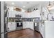 Bright kitchen with stainless steel appliances, white cabinets, modern tile backsplash, and hardwood floors at 2668 Corn Pile Rd., Myrtle Beach, SC 29588