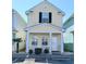 Charming yellow two-story home with a cozy front porch and white picket fence near parking at 337 Sailors Ct., Myrtle Beach, SC 29577