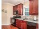 Well-equipped kitchen with cherry wood cabinets, granite countertops, and modern black appliances at 337 Sailors Ct., Myrtle Beach, SC 29577