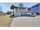 Charming two-story home featuring a covered porch, white railings, palm trees, and a spacious driveway at 417 Seabreeze Dr., Garden City Beach, SC 29576