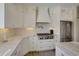 Modern kitchen featuring white cabinetry, stainless steel appliances, and marble countertops at 417 Seabreeze Dr., Garden City Beach, SC 29576