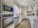 Beautiful kitchen with white cabinets, marble countertops, stainless steel appliances, and a large window at 417 Seabreeze Dr., Garden City Beach, SC 29576