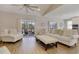 Airy living room with wood floors, comfortable seating, ceiling fan, and natural light from the sliding door at 417 Seabreeze Dr., Garden City Beach, SC 29576