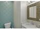 Chic powder room with modern wallpaper, elegant mirror, and a stylish vanity with marble countertop at 417 Seabreeze Dr., Garden City Beach, SC 29576