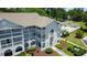 Aerial view of the condo with a pool and trees surrounding the grounds at 4430 Eastport Blvd. # L9, Little River, SC 29566