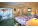 View of the bedroom with sliding glass doors, soft green carpet, and a view to the bathroom at 4430 Eastport Blvd. # L9, Little River, SC 29566
