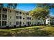 Exterior view of a multi-story building with lush green lawn, mature trees, and private screened balconies at 4430 Eastport Blvd. # L9, Little River, SC 29566