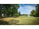 Scenic golf course view with lush green fairways, mature trees, and a glimpse of a home in the background at 4430 Eastport Blvd. # L9, Little River, SC 29566