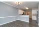 Open dining room with white trim, chandelier, light gray paint, hardwood floors, and a view to the kitchen at 505 Hay Hill Ln. # B, Myrtle Beach, SC 29579