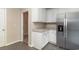 Bright corner kitchen with white cabinets, stainless refrigerator, and a view of an adjacent room at 505 Hay Hill Ln. # B, Myrtle Beach, SC 29579